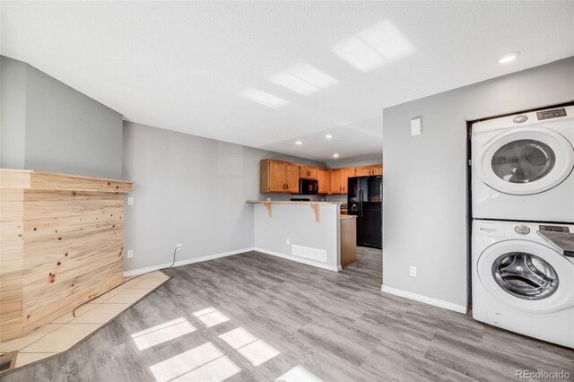 3090 W 107th Pl Unit F, Westminster, CO 80031 - washroom featuring stacked washing machine and dryer, light wood-type flooring, and recessed lighting