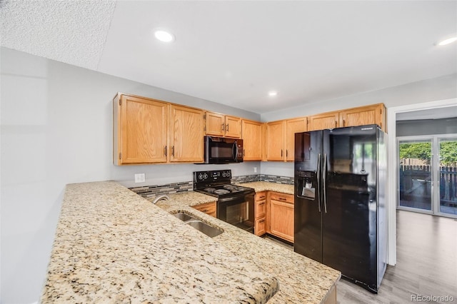 3090 W 107th Pl Unit F, Westminster, CO 80031 - kitchen with black appliances, light stone countertops, recessed lighting, a peninsula, and light wood finished floors