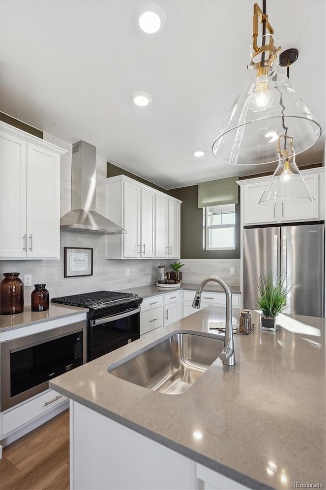 22384 E 6th Pl, Aurora, CO 80018 - kitchen with wall chimney exhaust hood, appliances with stainless steel finishes, a sink, white cabinetry, and tasteful backsplash