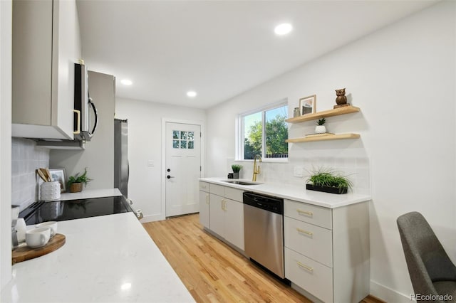 kitchen featuring backsplash, stainless steel appliances, light hardwood / wood-style floors, and sink