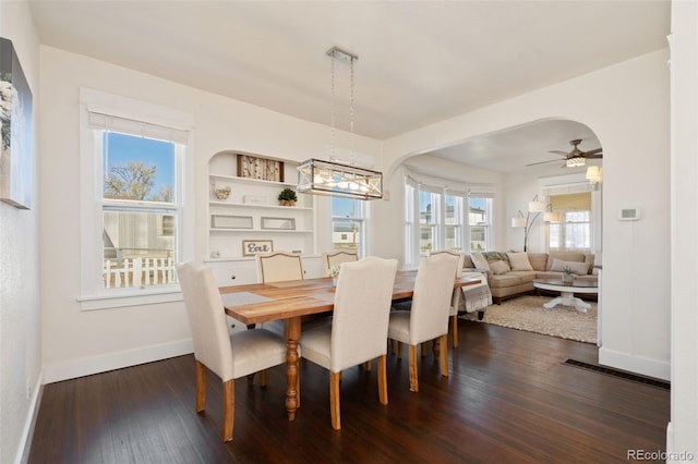224 4th Ave, Severance, CO 80550 - dining space featuring dark wood-style floors, arched walkways, a ceiling fan, and a chandelier