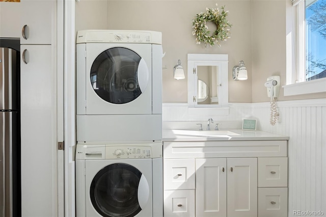 224 4th Ave, Severance, CO 80550 - laundry area featuring stacked washer / drying machine and a wainscoted wall