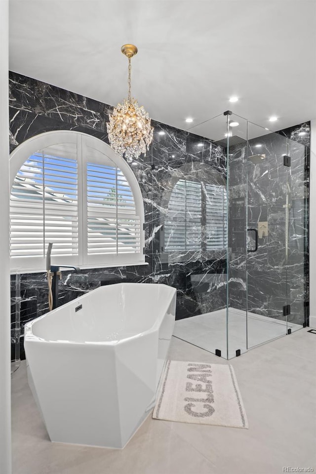 2062 Hyacinth Rd, Highlands Ranch, CO 80129 - bathroom with tile walls, a marble finish shower, a freestanding tub, a chandelier, and recessed lighting
