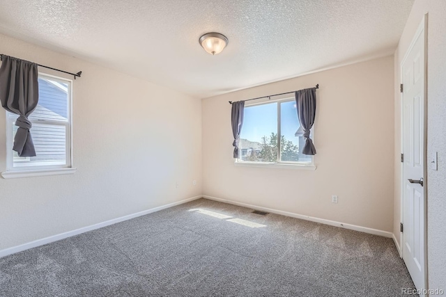 carpeted spare room with a textured ceiling