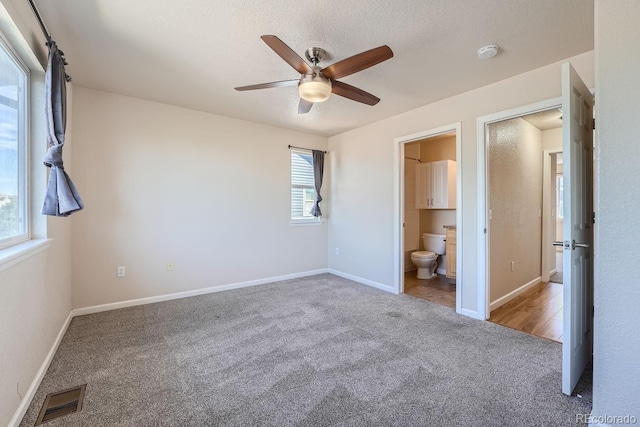 unfurnished bedroom featuring ceiling fan, connected bathroom, and carpet flooring