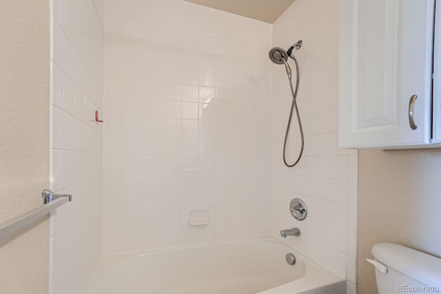 bathroom featuring tiled shower / bath combo and toilet