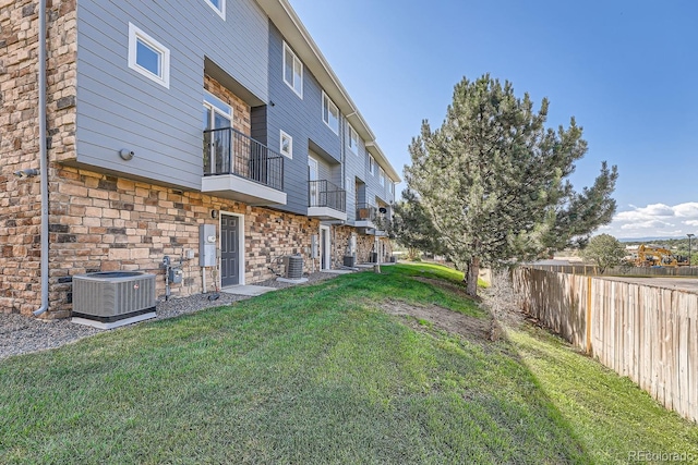 view of yard featuring a balcony and central air condition unit