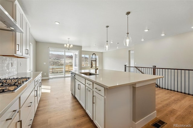 kitchen featuring recessed lighting, visible vents, wall chimney exhaust hood, stainless steel appliances, and a sink