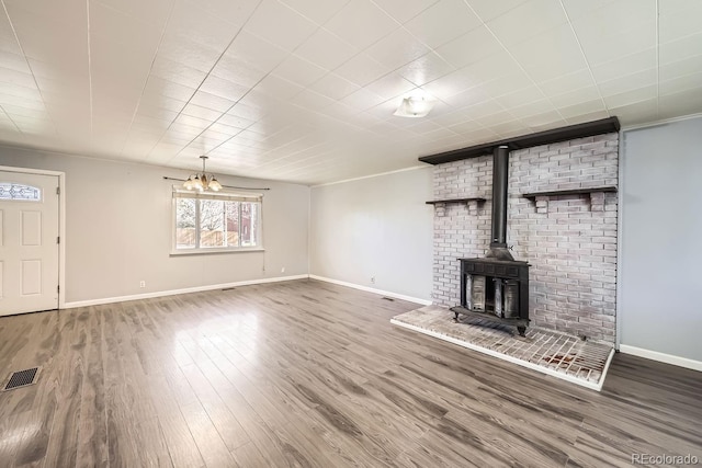 unfurnished living room featuring a wood stove and hardwood / wood-style floors