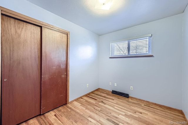 unfurnished bedroom with light hardwood / wood-style floors and a closet