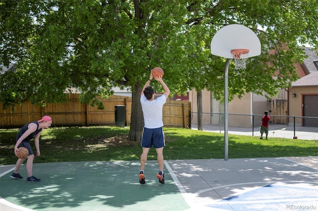 view of basketball court featuring fence
