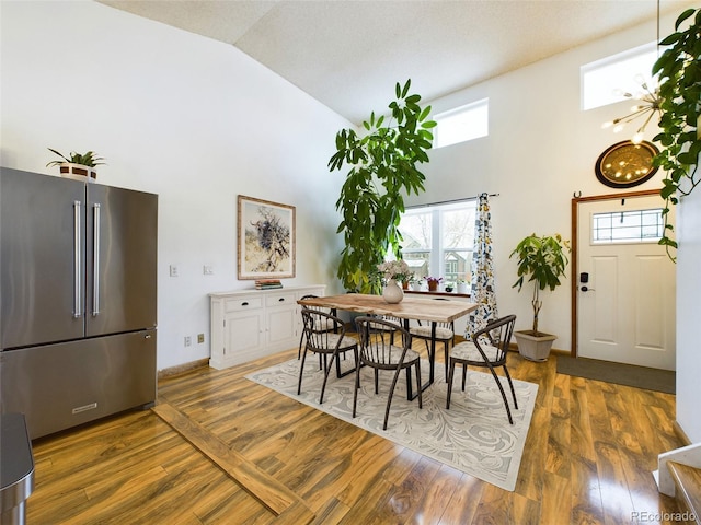 dining room featuring high vaulted ceiling and dark hardwood / wood-style flooring