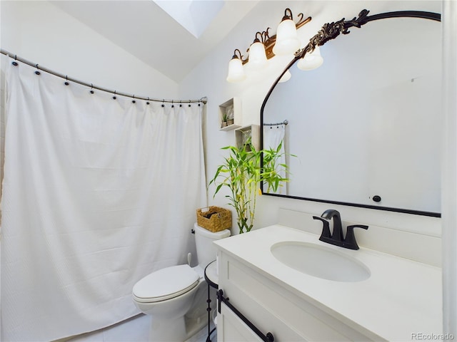 bathroom with toilet, vanity, and vaulted ceiling with skylight