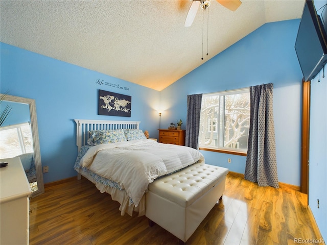 bedroom with wood-type flooring, vaulted ceiling, ceiling fan, and a textured ceiling