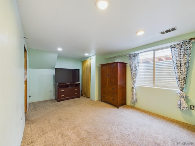 unfurnished bedroom with light colored carpet and a closet