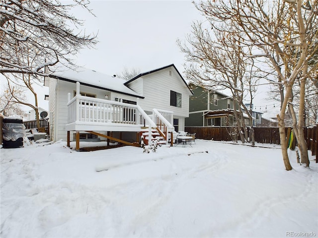 view of snow covered back of property