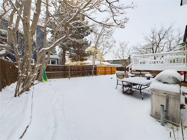 snowy yard with a wooden deck