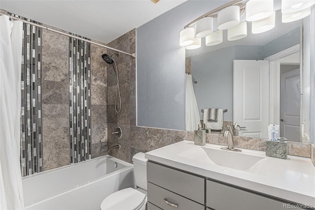 bathroom featuring vanity, toilet, shower / tub combo with curtain, and a textured wall