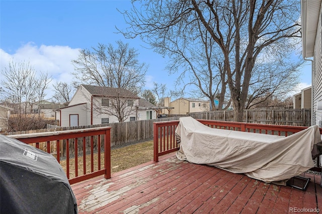 wooden deck with a residential view, a fenced backyard, and area for grilling