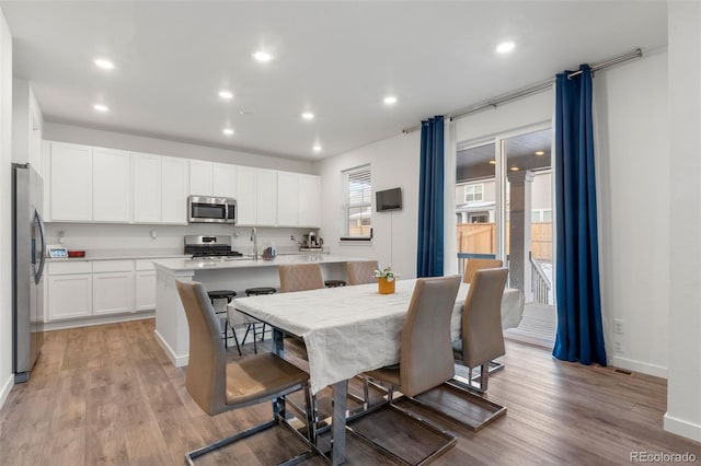 dining room featuring sink and light hardwood / wood-style flooring