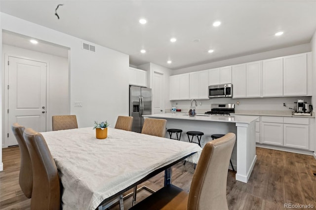 dining room with dark hardwood / wood-style floors and sink