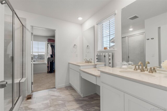 bathroom with vanity, a healthy amount of sunlight, and a shower with shower door