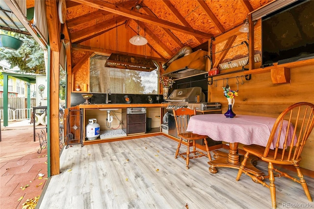 exterior space with light hardwood / wood-style flooring, beam ceiling, sink, and high vaulted ceiling