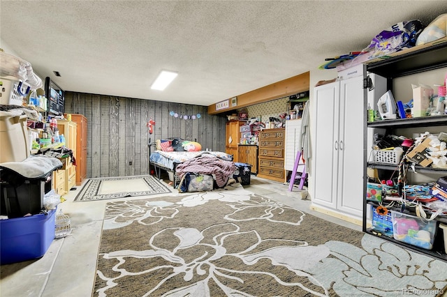 bedroom featuring a textured ceiling and wood walls