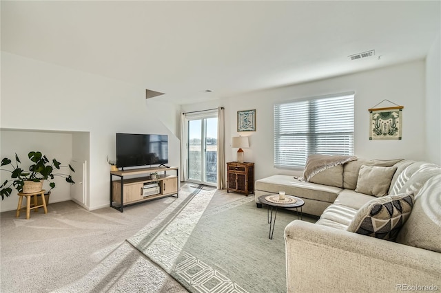 living area featuring light colored carpet, visible vents, and baseboards