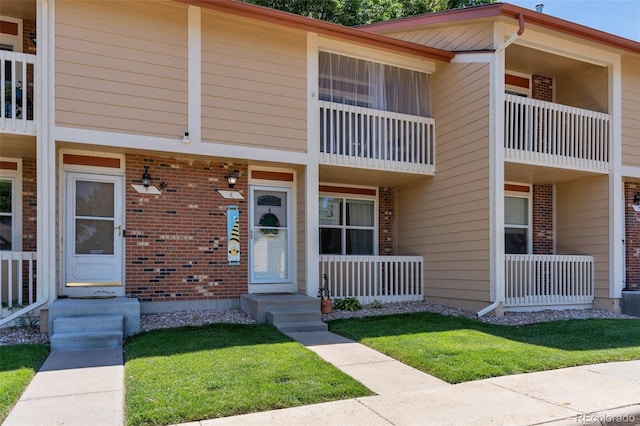 11604 Community Center Dr Unit 8, Northglenn, CO 80233 - property entrance with brick siding, a porch, and a lawn