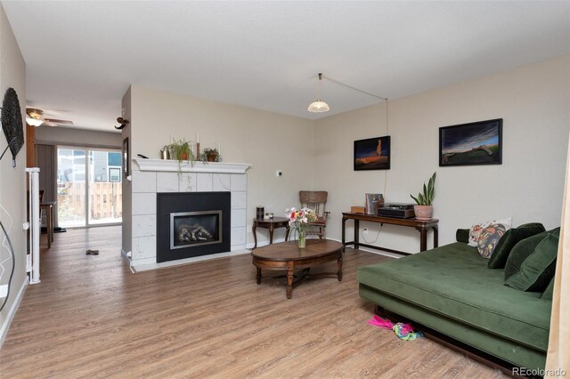 11604 Community Center Dr Unit 8, Northglenn, CO 80233 - living area featuring light wood-type flooring, a tile fireplace, and ceiling fan