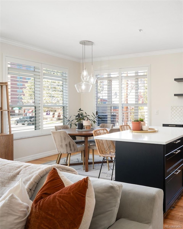 interior space with crown molding, plenty of natural light, baseboards, and light wood-type flooring