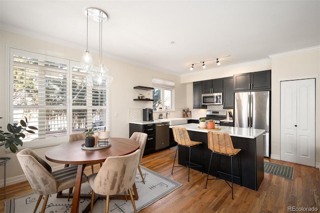 dining room with baseboards, wood finished floors, and crown molding