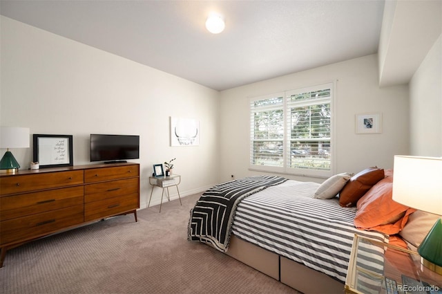 bedroom featuring baseboards and light colored carpet