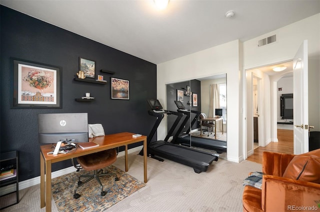 office space with arched walkways, visible vents, baseboards, and carpet floors