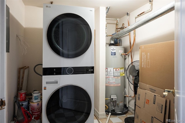 clothes washing area featuring water heater, laundry area, and stacked washer / drying machine