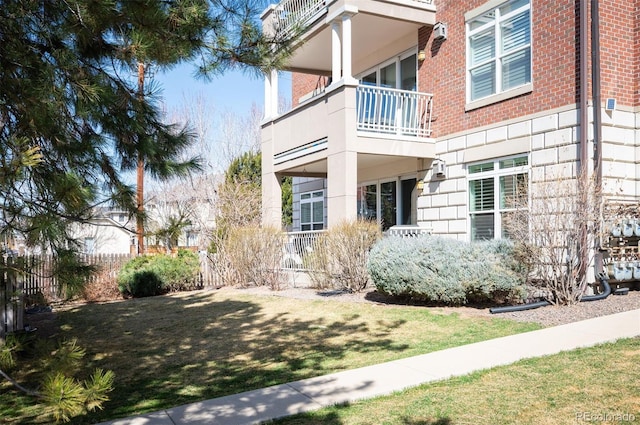 view of exterior entry with a yard and brick siding