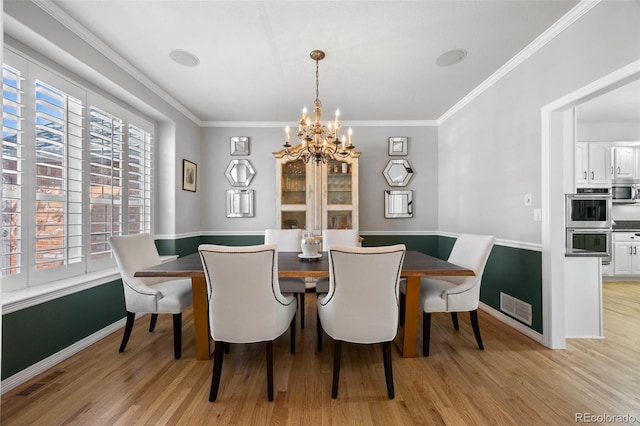 404 Yarrow Pl, Castle Pines, CO 80108 - dining space featuring a chandelier, light wood-style flooring, baseboards, and ornamental molding