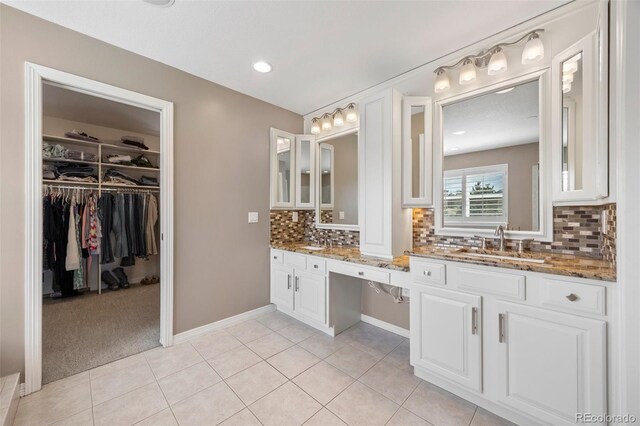404 Yarrow Pl, Castle Pines, CO 80108 - full bath with backsplash, double vanity, tile patterned flooring, a spacious closet, and baseboards