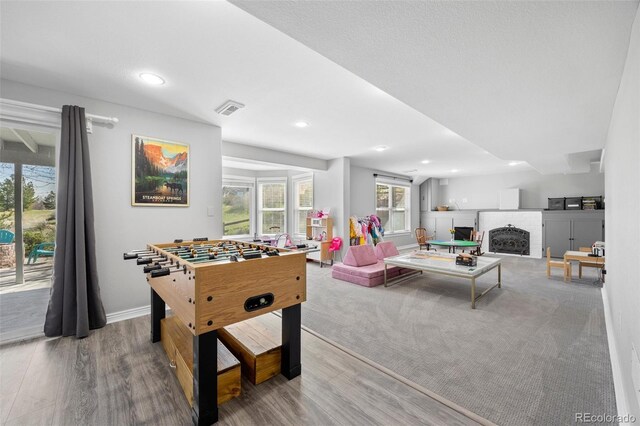 404 Yarrow Pl, Castle Pines, CO 80108 - playroom with wood finished floors, a brick fireplace, and recessed lighting