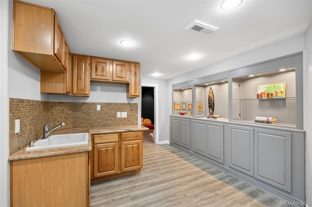 404 Yarrow Pl, Castle Pines, CO 80108 - kitchen with a sink, light wood-style flooring, decorative backsplash, light stone counters, and recessed lighting