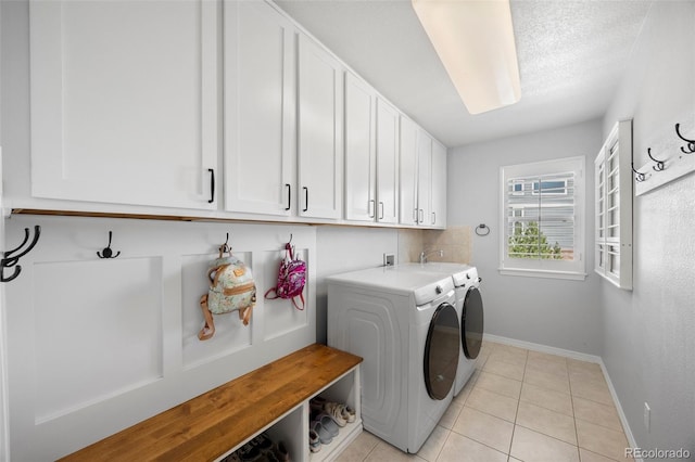 404 Yarrow Pl, Castle Pines, CO 80108 - clothes washing area with cabinet space, washing machine and clothes dryer, baseboards, and light tile patterned floors