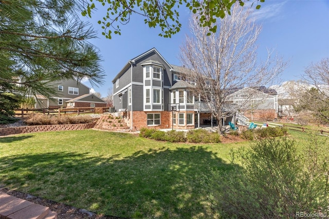 404 Yarrow Pl, Castle Pines, CO 80108 - rear view of house featuring stairway, a wooden deck, a yard, and brick siding