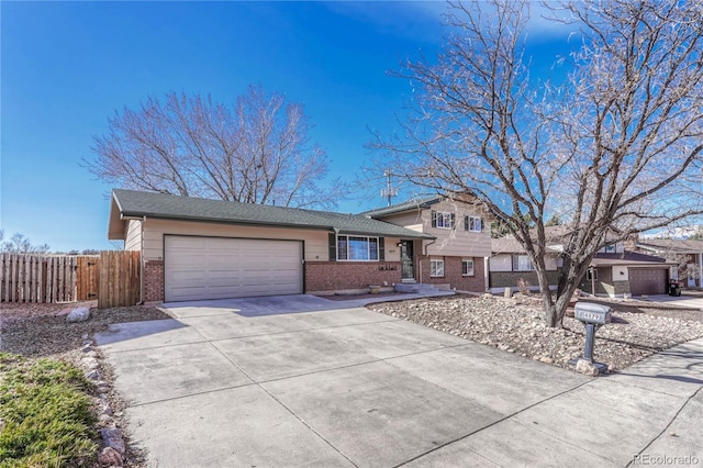 split level home with brick siding, concrete driveway, an attached garage, and fence