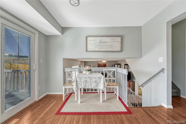 dining space with baseboards and wood finished floors