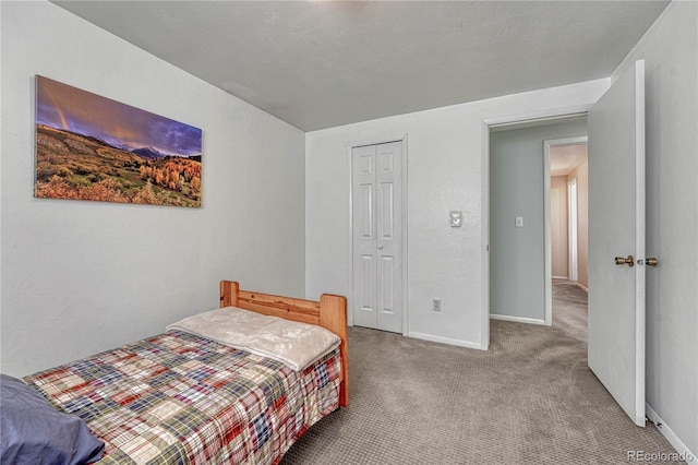 bedroom featuring a closet, baseboards, and carpet flooring