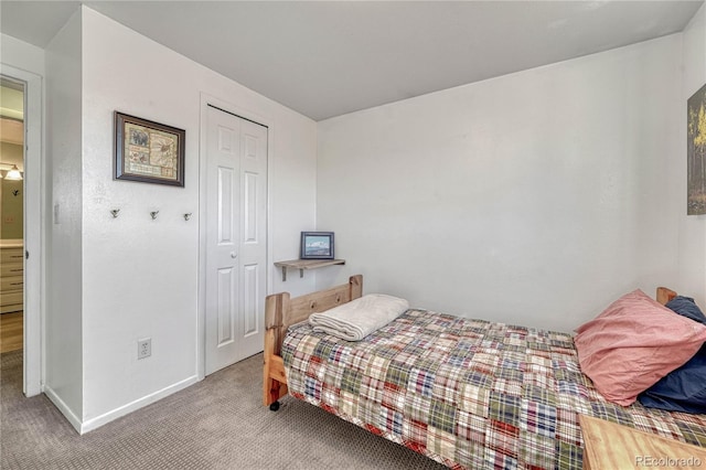 bedroom with a closet, carpet flooring, and baseboards