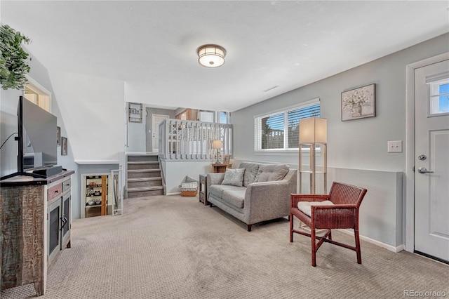 carpeted living room featuring stairway, a fireplace, and baseboards