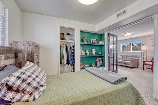 carpeted bedroom with a closet and visible vents