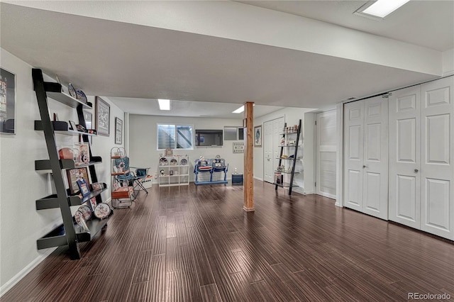 workout area with baseboards and wood finished floors